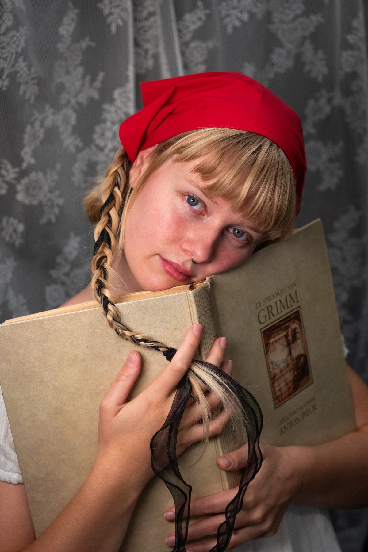Portrait of the founder in a red headscarf holding a book of Grimm fairytales